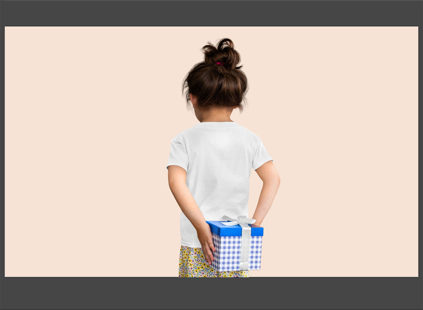 Child holding two gift boxes against a beige background