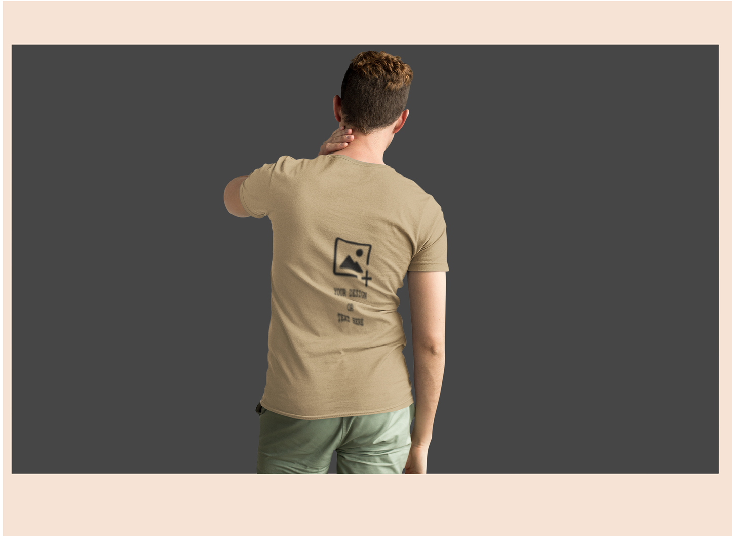 Person wearing a beige t-shirt with a logo on the back, standing against a dark background.