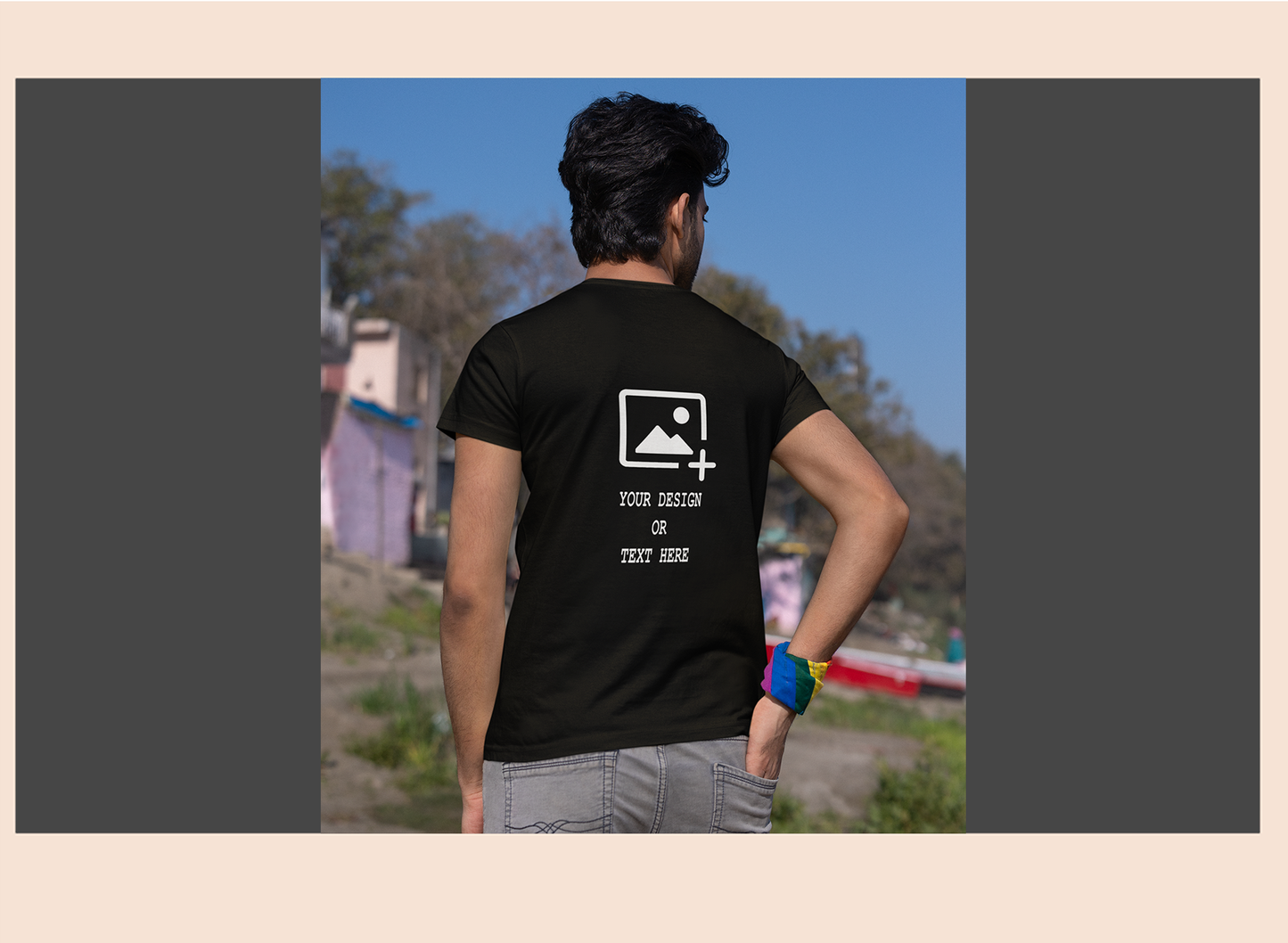 Person wearing a black t-shirt with customizable design text on the back, standing outdoors.