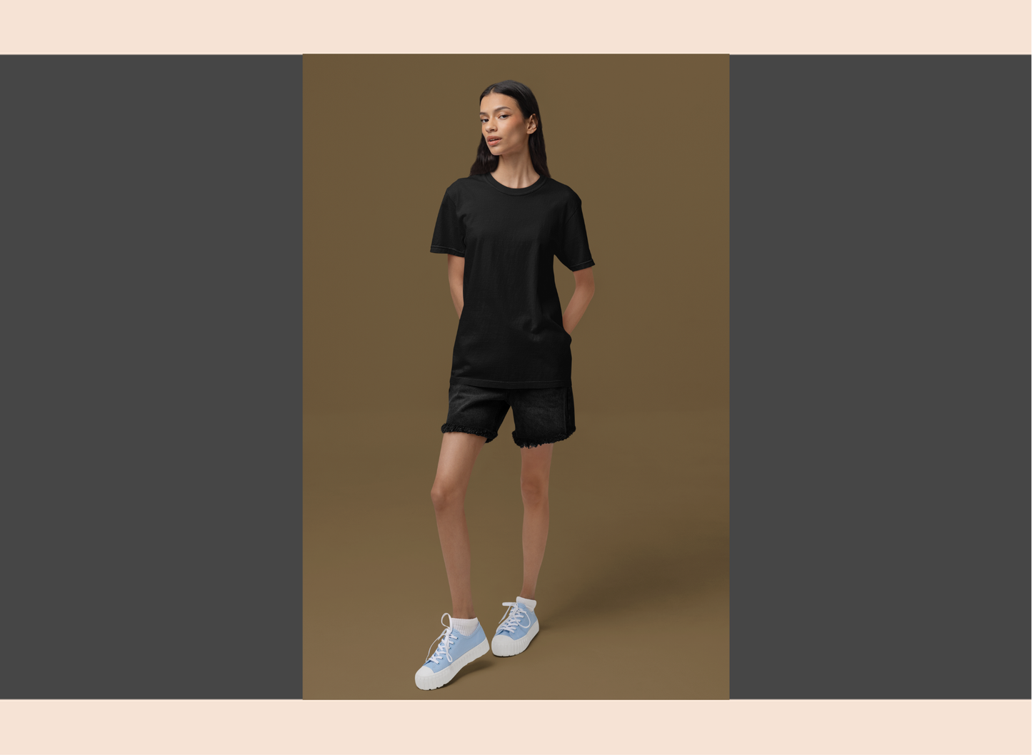 Person wearing a black outfit with white sneakers on a brown background