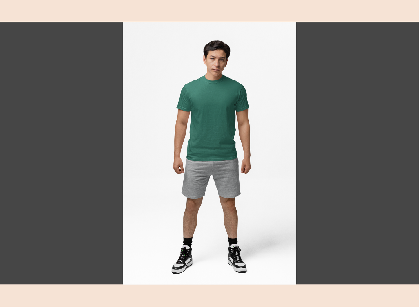 Man wearing a green t-shirt and gray shorts on a white background