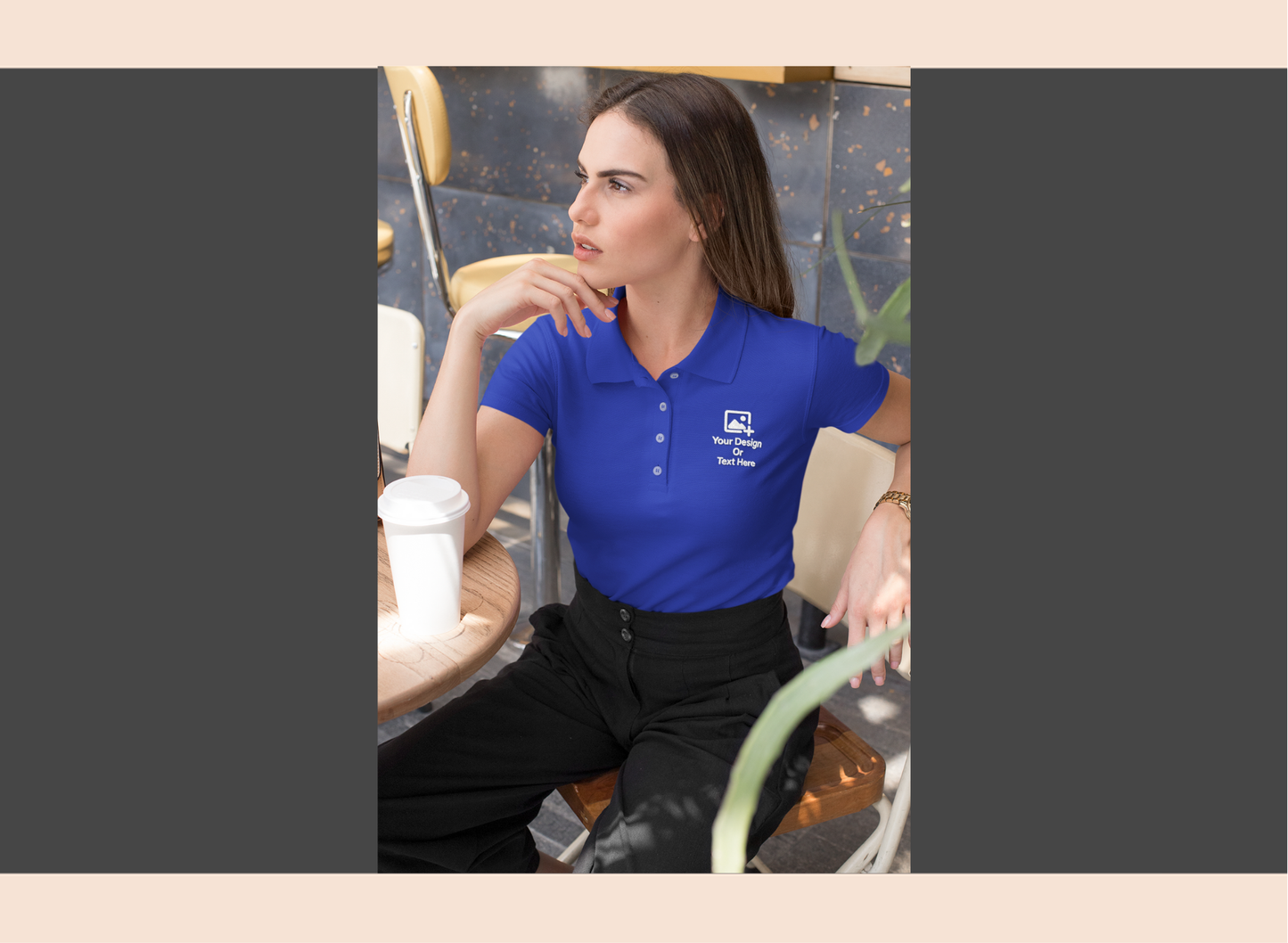 Woman wearing a blue polo shirt with a logo, sitting at a table.