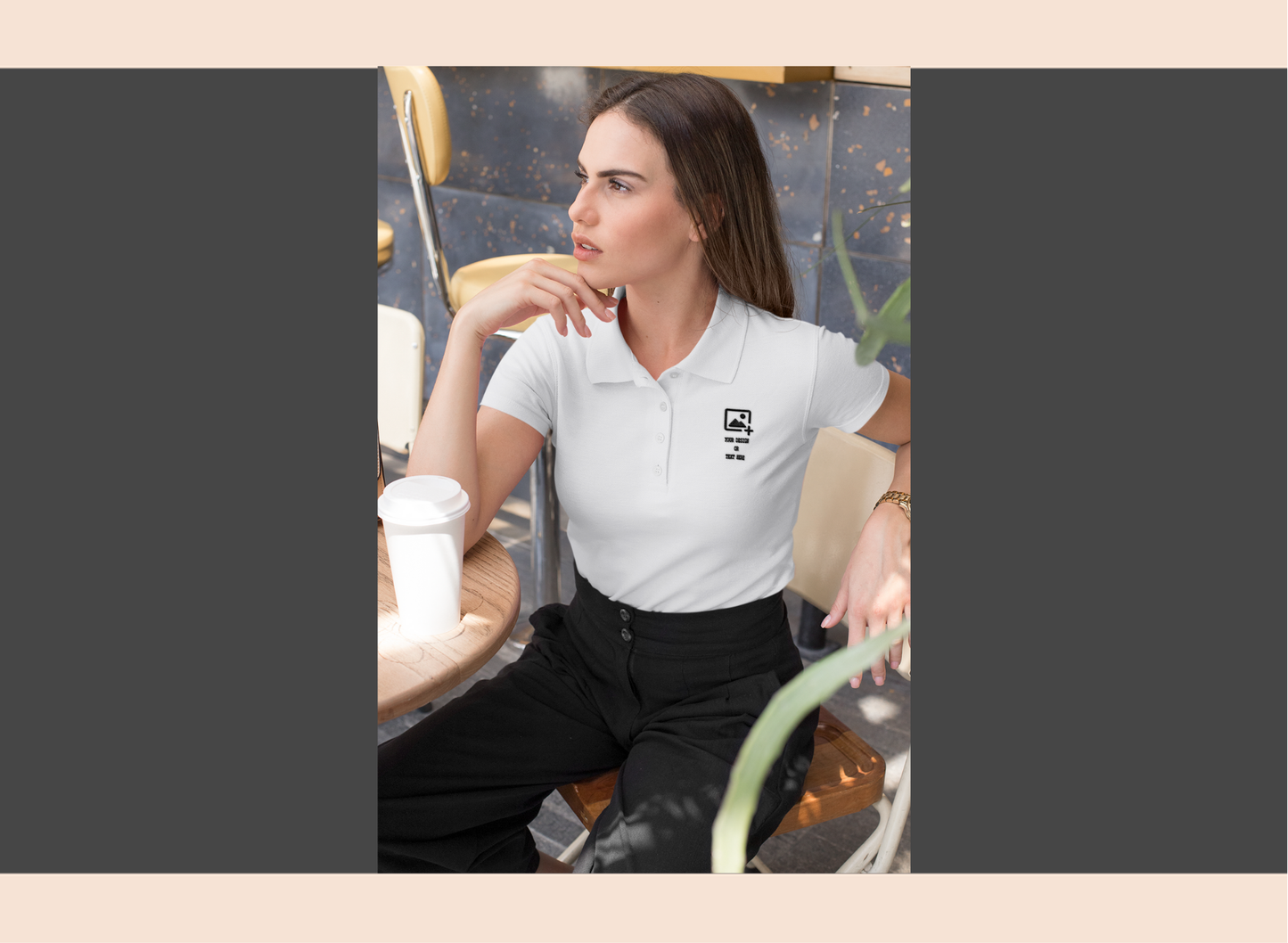 Woman wearing a blue polo shirt with a logo, sitting at a table.