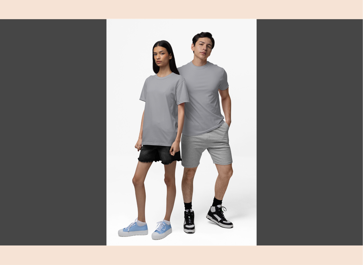 Two people wearing matching gray outfits on a plain background