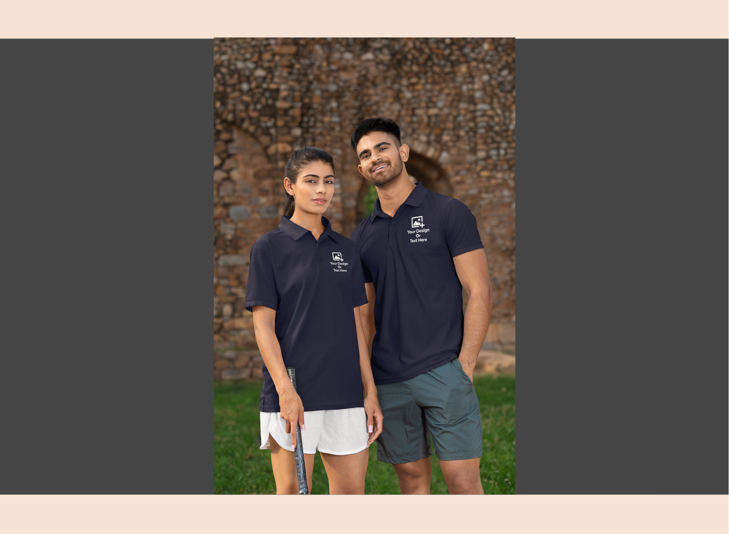 Two people wearing black polo shirts with logos standing outdoors against a brick wall.