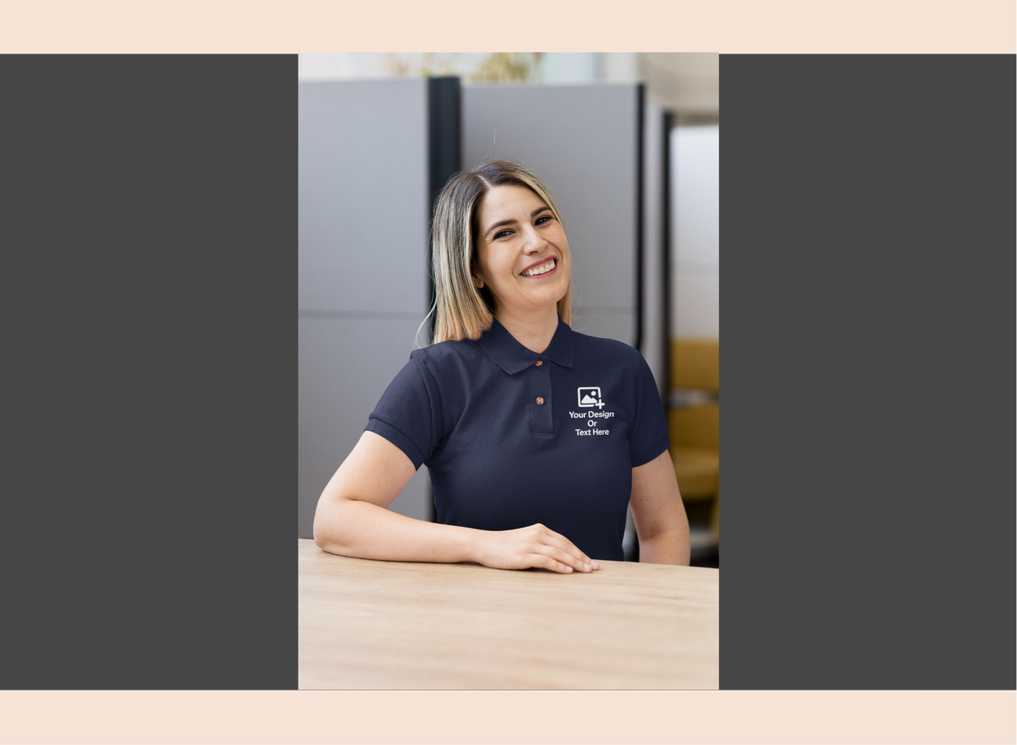 Woman wearing a navy blue polo shirt with a logo, sitting at a desk.
