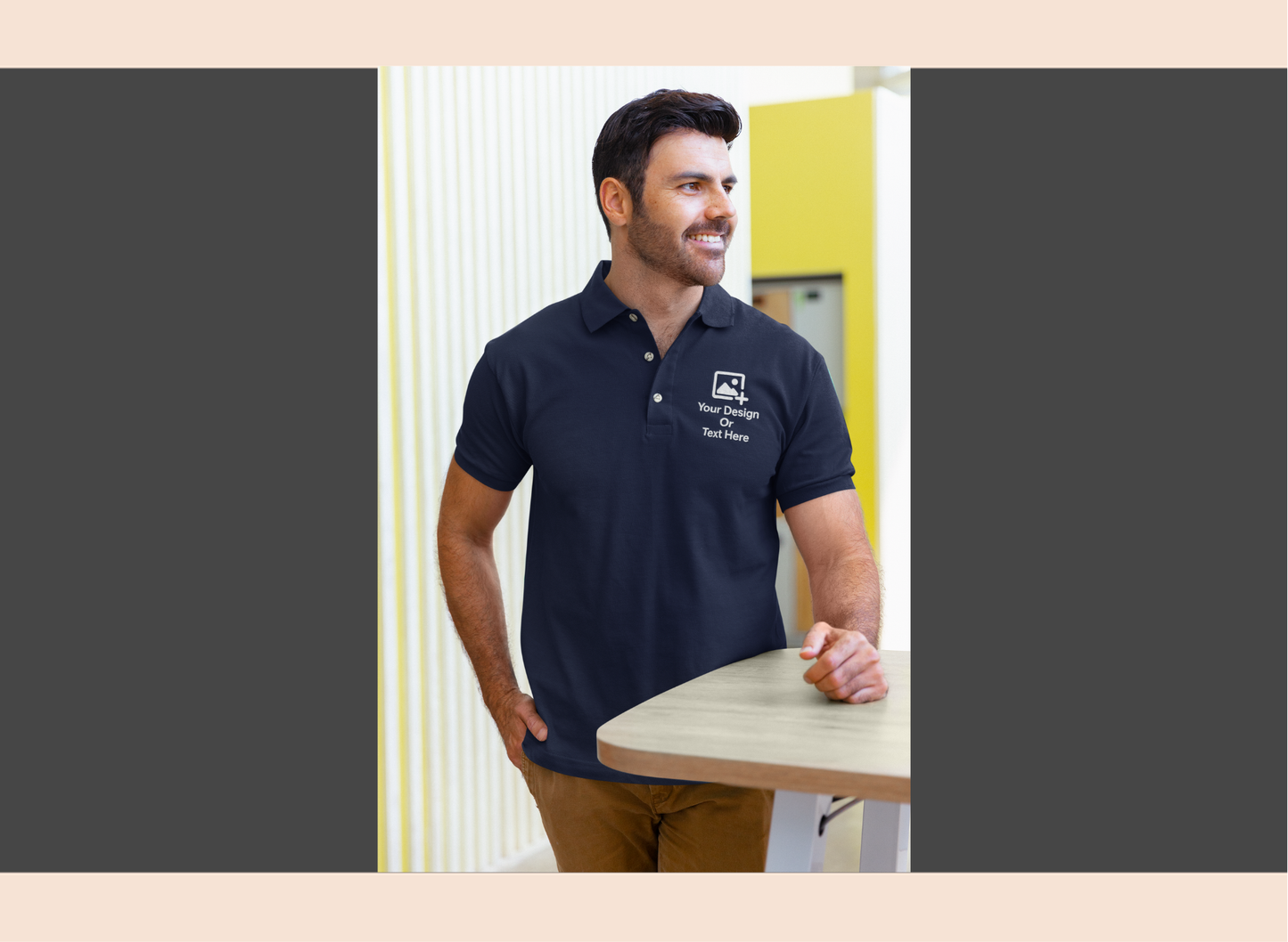 Man wearing a black polo shirt with a logo, standing indoors.