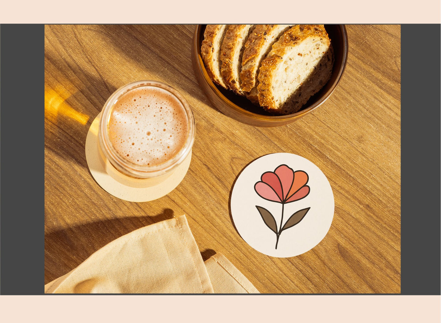 Glass of coffee, bowl of bread, and floral coaster on a wooden surface
