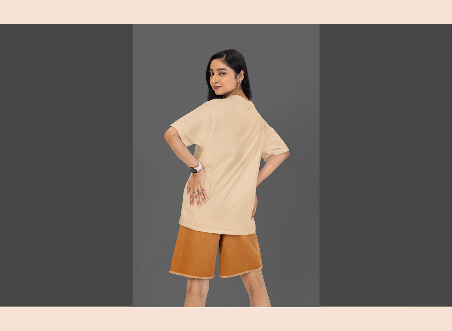 Woman wearing a beige top and brown shorts on a gray background