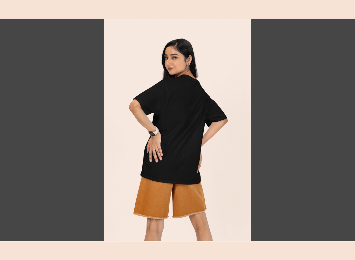 Woman wearing a black top and brown shorts on a beige background