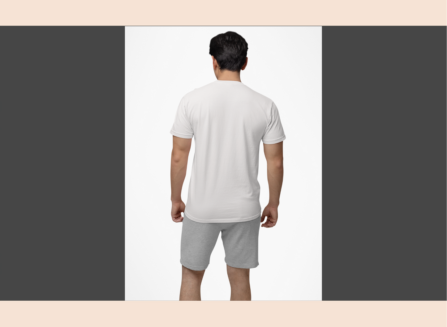 Man wearing a white t-shirt and gray shorts on a plain background