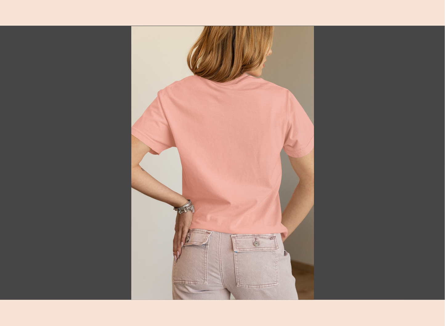 Person wearing a pink t-shirt and light-colored pants, standing with hands on hips.