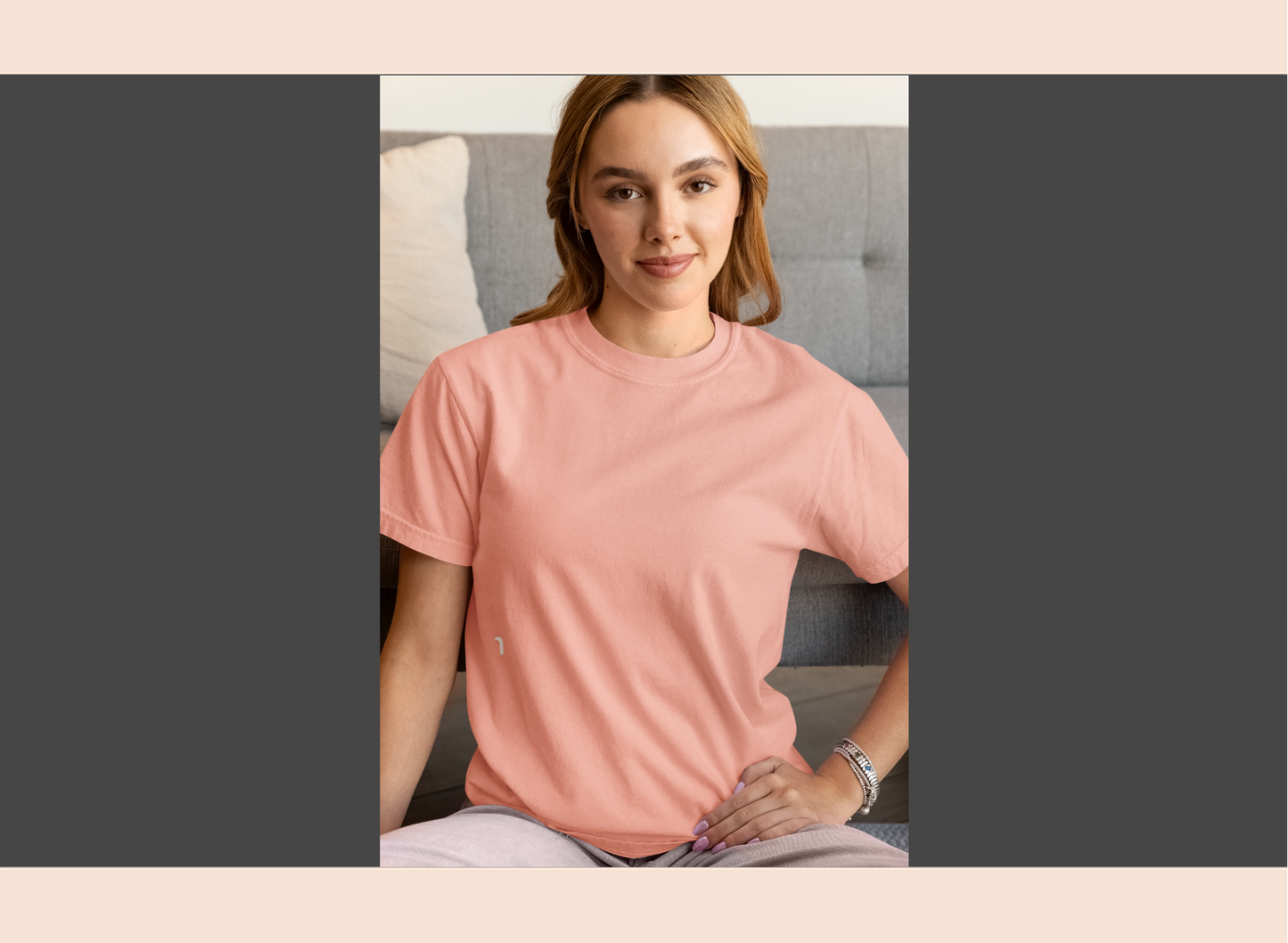 Woman wearing a pink shirt sitting on a couch with a neutral background