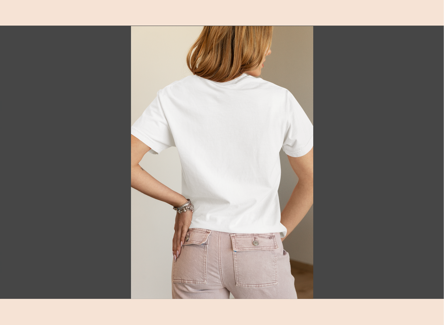 Person wearing a white t-shirt and light-colored pants in a neutral setting