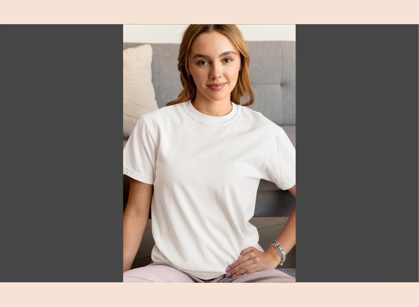Woman wearing a white t-shirt sitting on a couch.