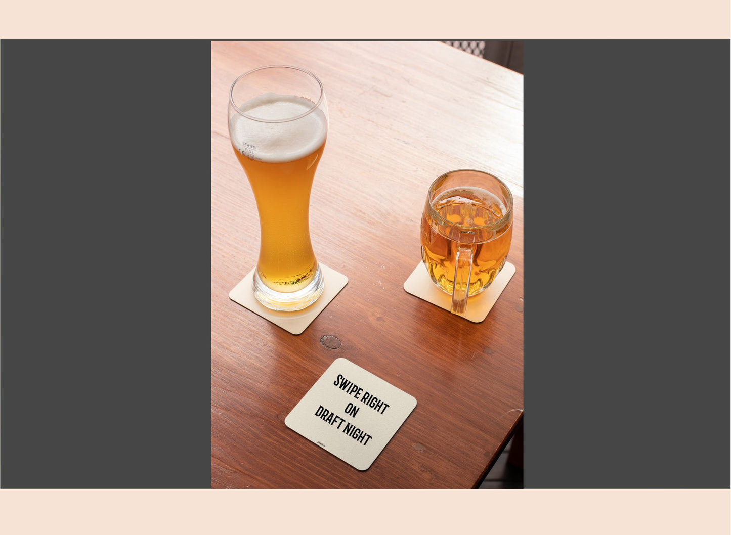 Two glasses of beer on a wooden table with a coaster underneath.