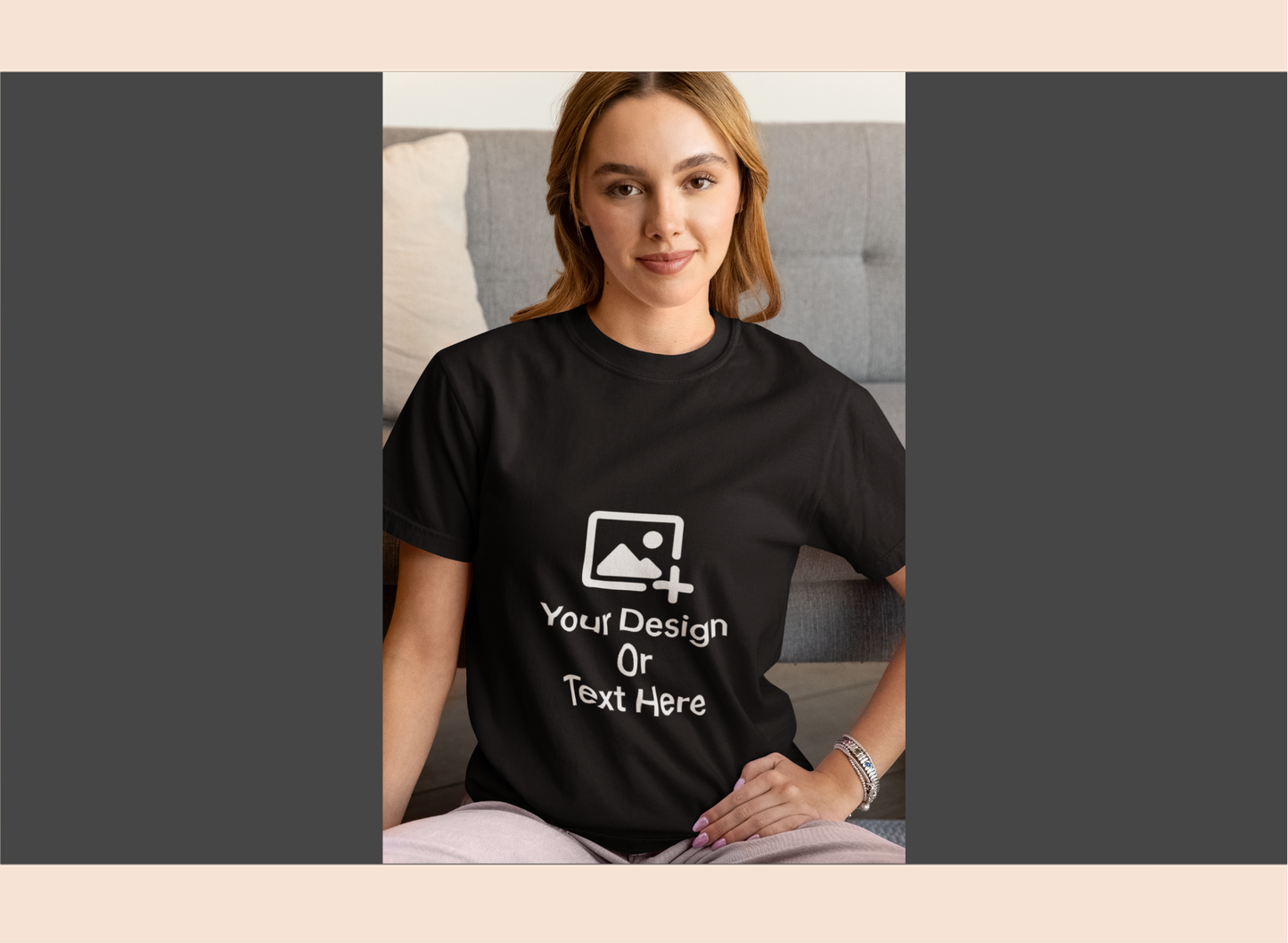 Person wearing a black t-shirt with customizable design area, sitting on a couch.