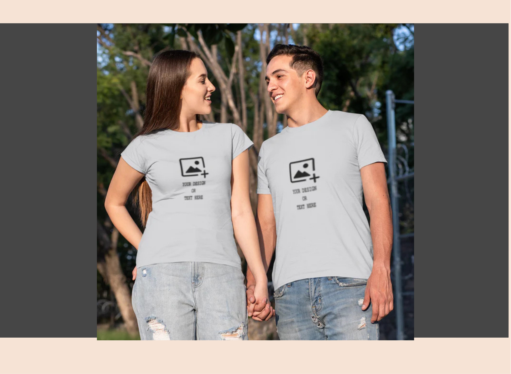 Two people wearing matching gray t-shirts with a graphic design outdoors.
