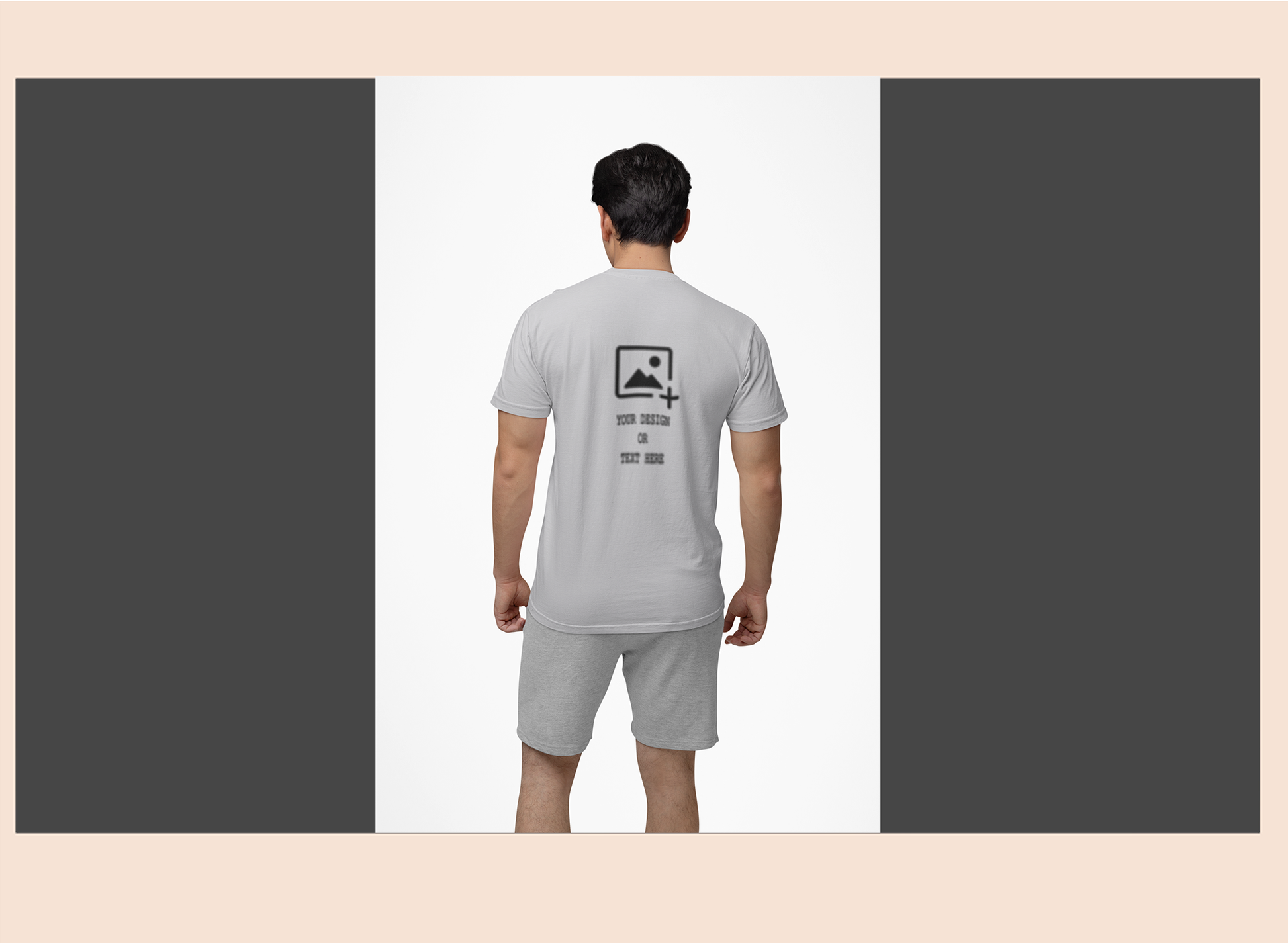 Man wearing a gray t-shirt and shorts set with a design on the back, standing against a plain background.