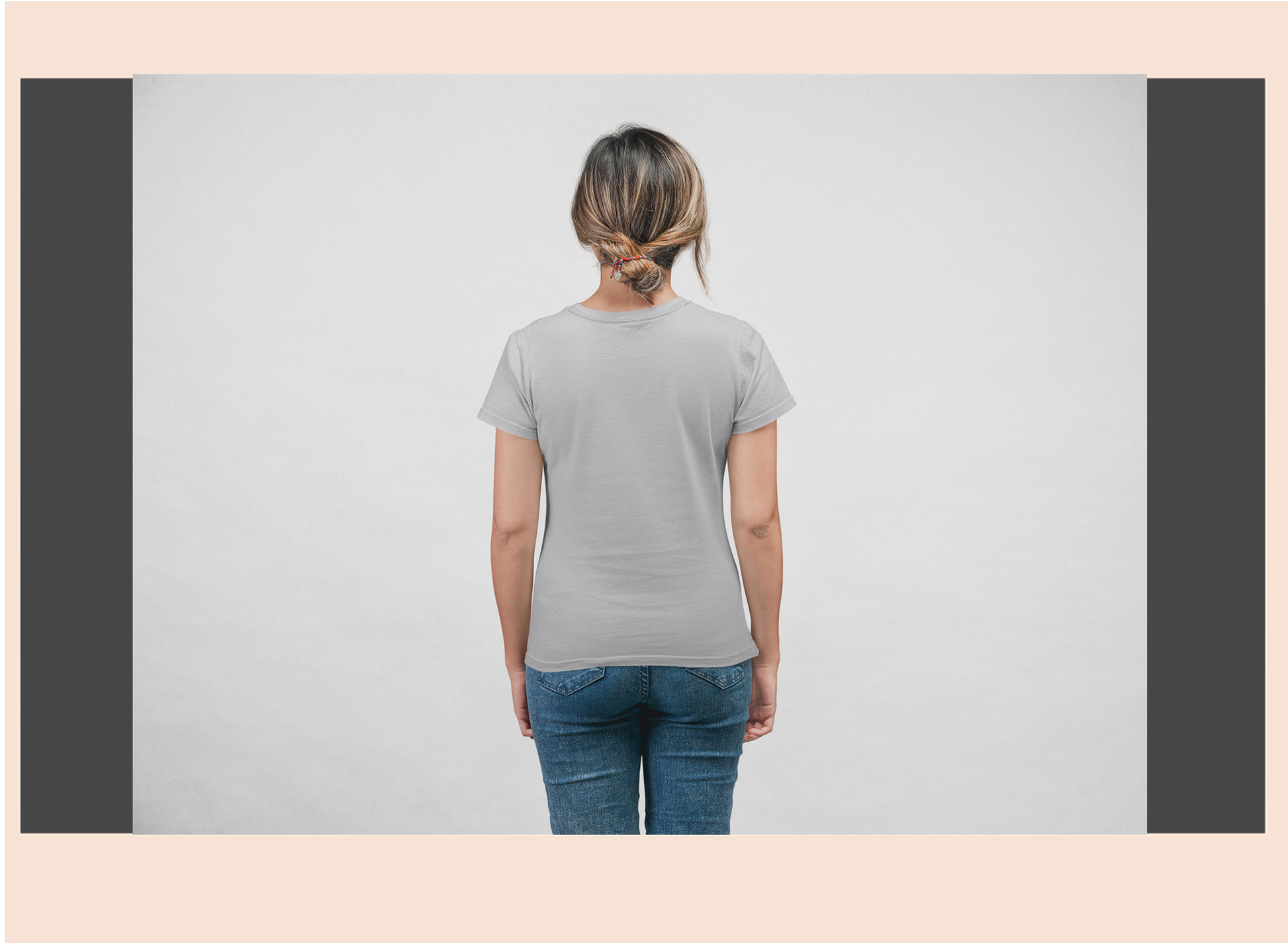 Person wearing a plain gray t-shirt and blue jeans on a light gray background