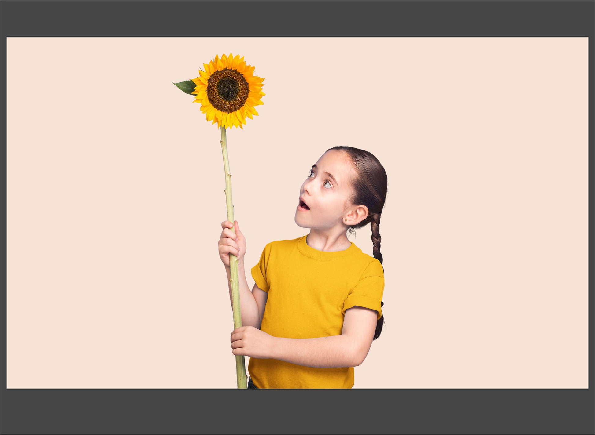 Child holding a sunflower against a beige background