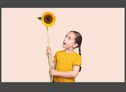 Child holding a sunflower against a beige background