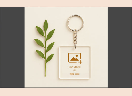Keychain with customizable design area next to a green leaf on a neutral background