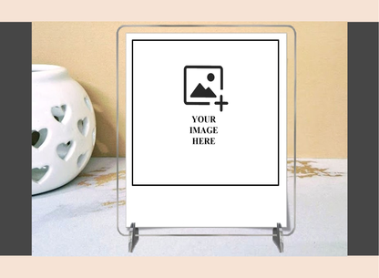 Clear acrylic photo frame on a decorative surface with a heart-patterned candle.