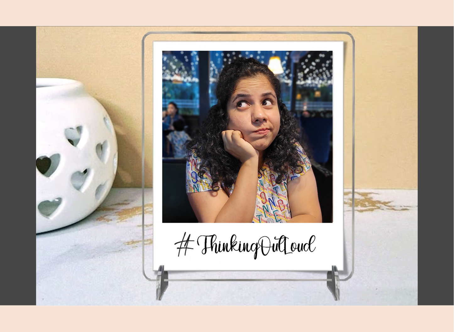 Display stand with a photo of a woman and '#ThinkingOutloud' text on a polaroid acrylic frame.