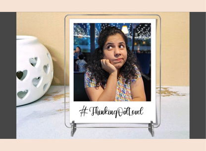 Display stand with a photo of a woman and '#ThinkingOutloud' text on a polaroid acrylic frame.