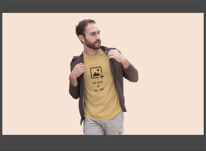 Man wearing a beige t-shirt with a graphic design on a beige background