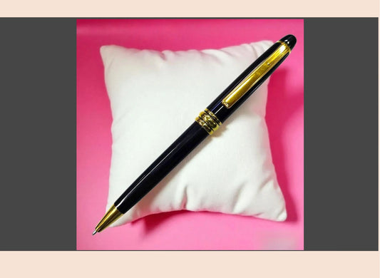 Pen with gold accents on a white cushion against a pink background