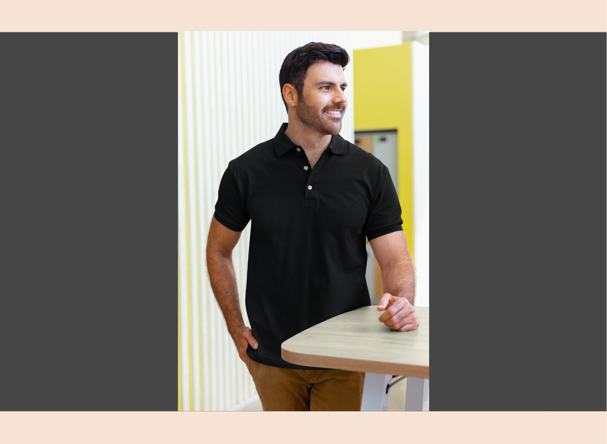Man wearing a black polo shirt standing in an office setting