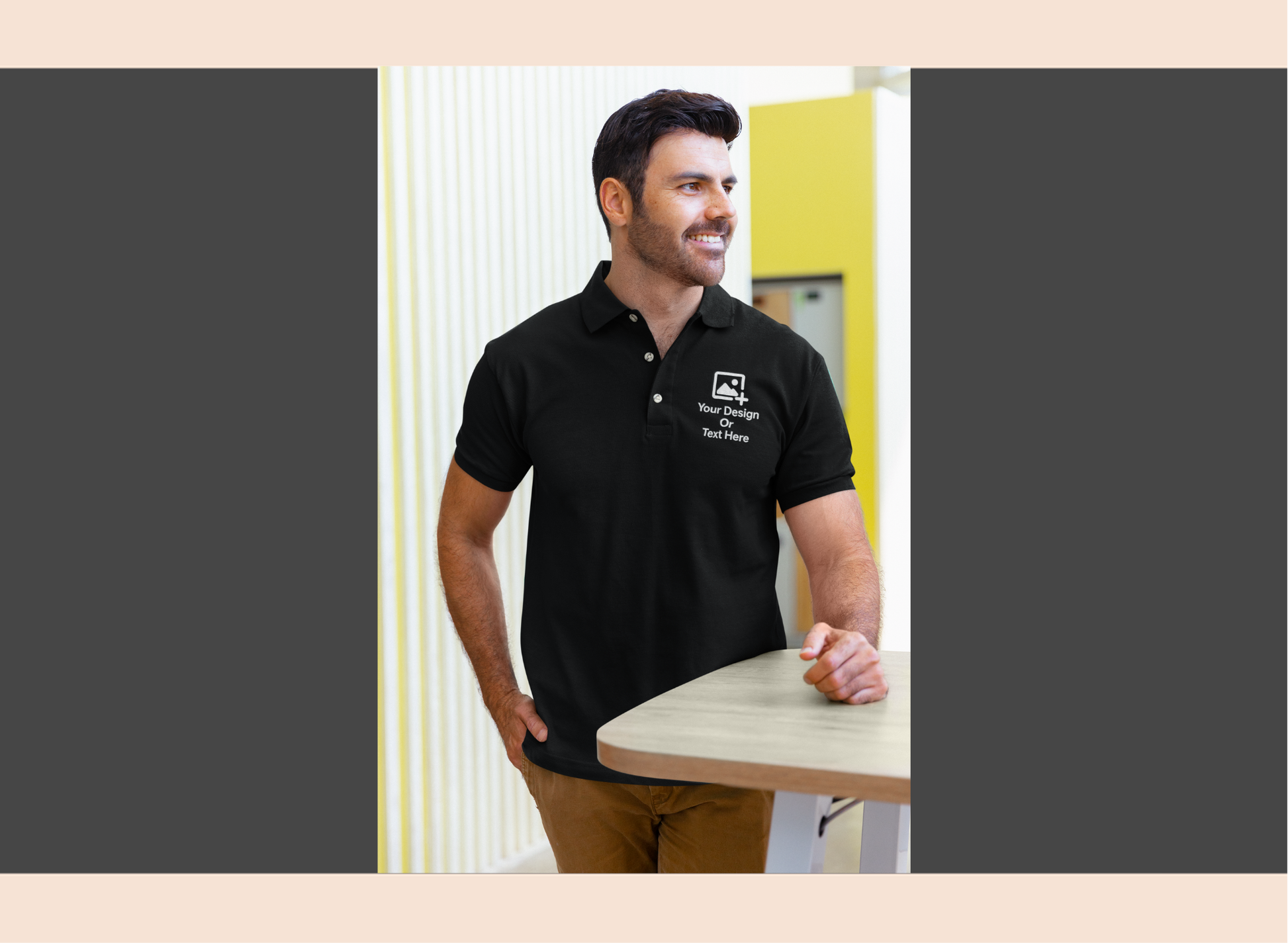Man wearing a black polo shirt with a logo, standing indoors.