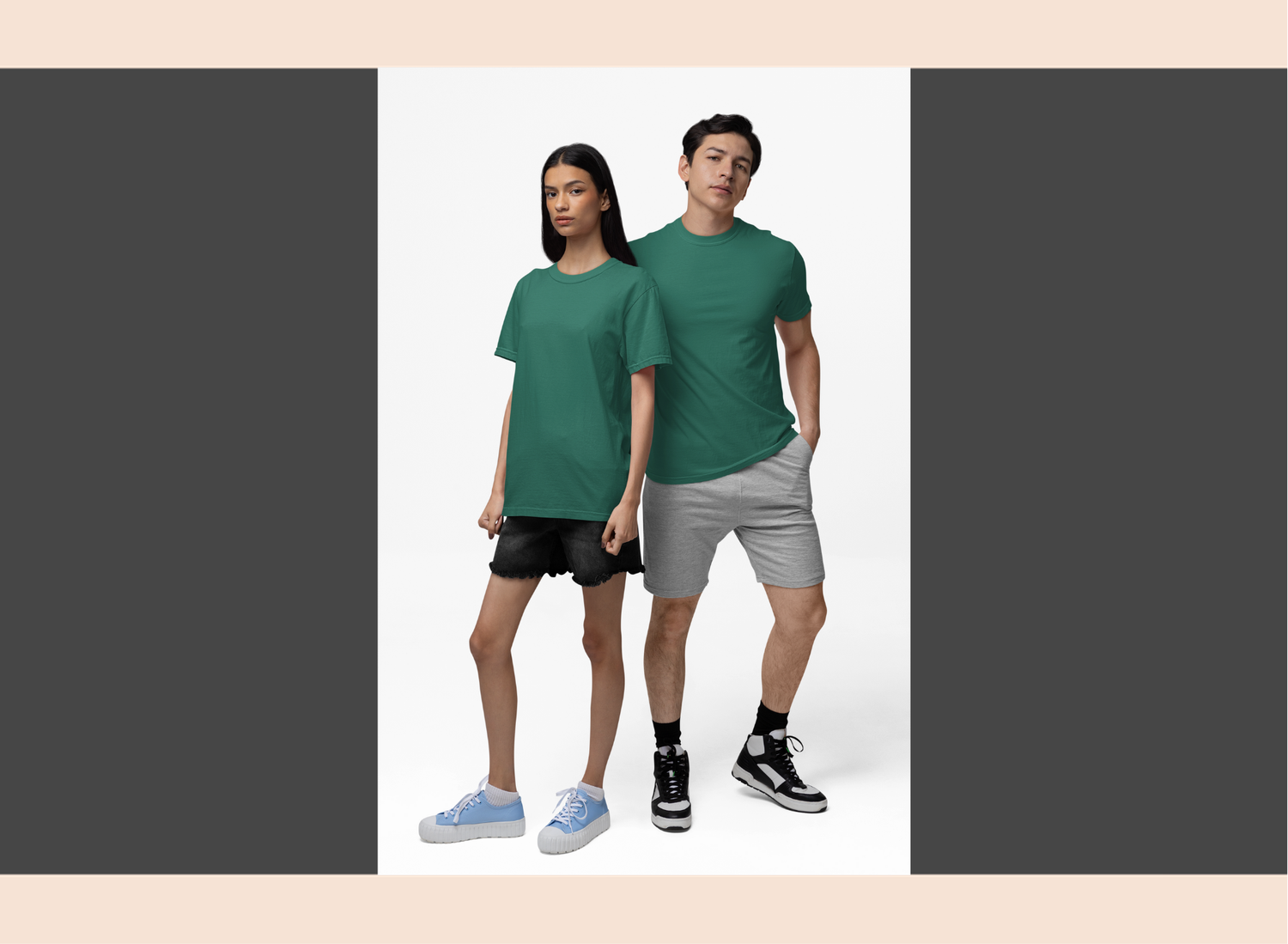 Two people wearing green t-shirts and gray shorts on a white background