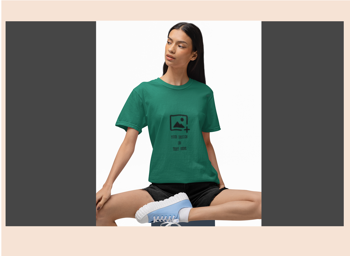 Woman wearing a green t-shirt with a graphic design sitting on a white background