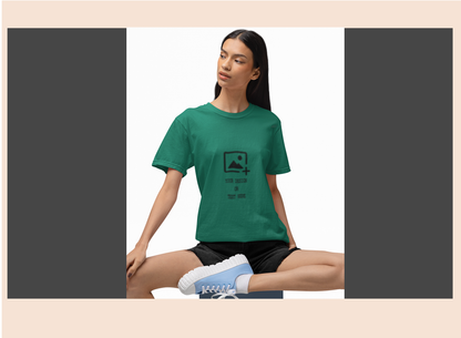 Woman wearing a green t-shirt with a graphic design sitting on a white background