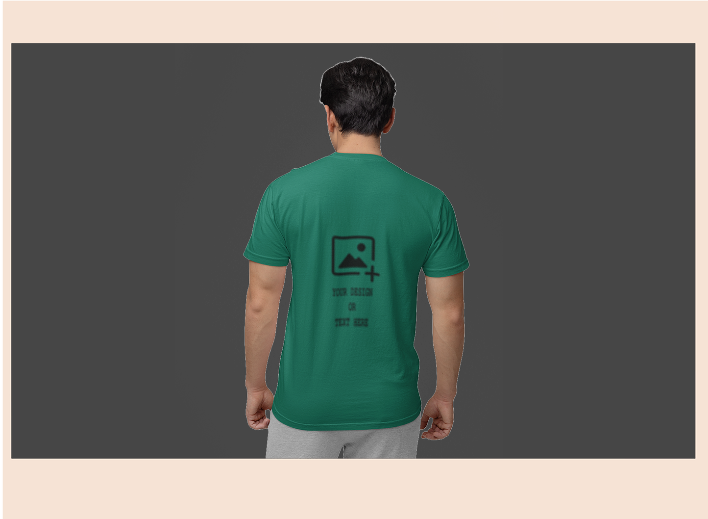Person wearing a green t-shirt with a logo on the back against a dark background
