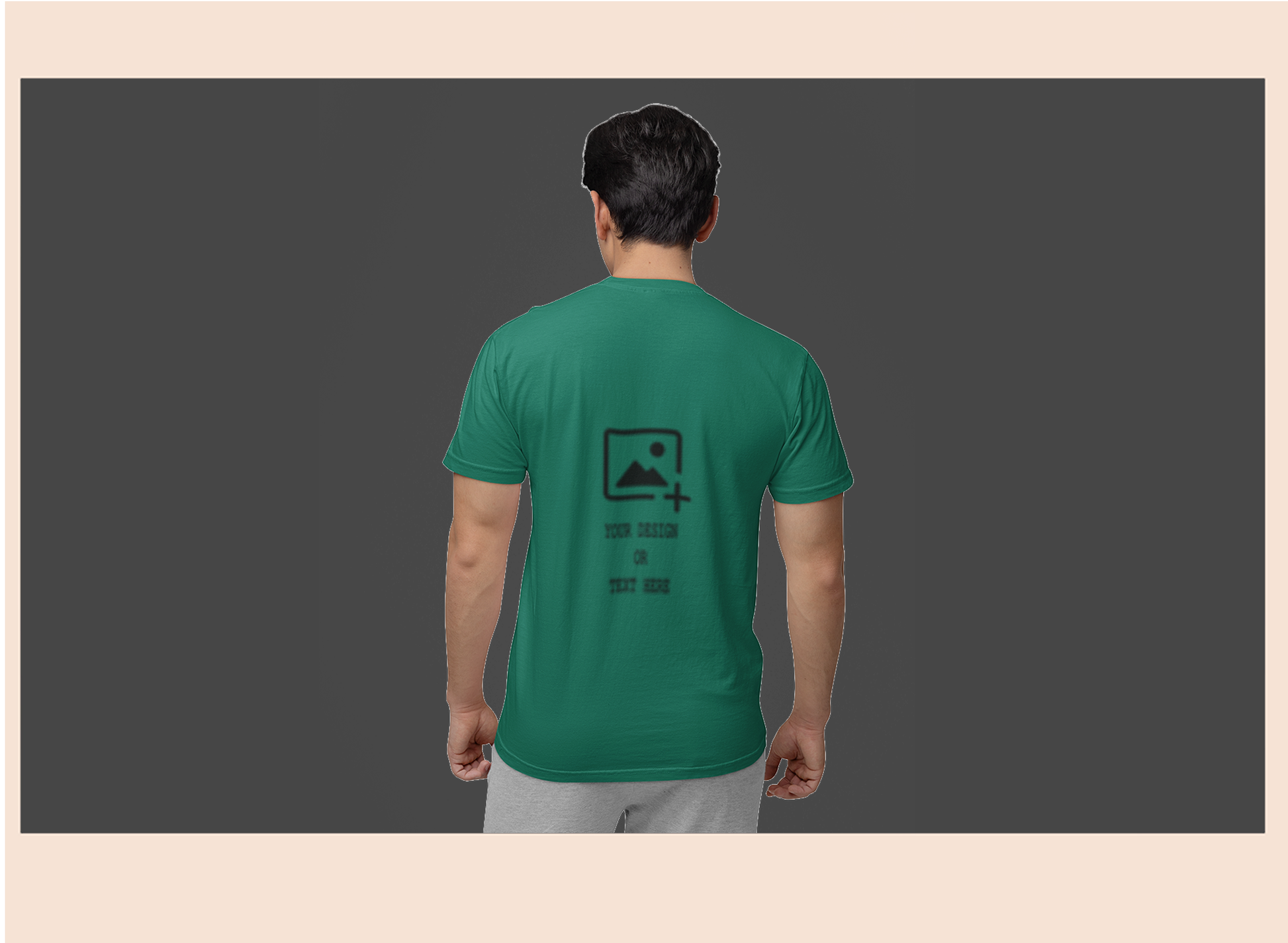 Person wearing a green t-shirt with a logo on the back against a dark background
