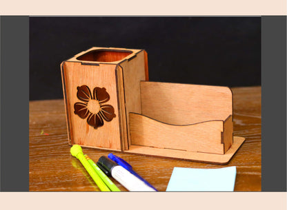 Wooden desk organizer with floral design on a wooden surface with stationery items.