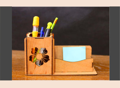 Wooden desk organizer with colorful pens and a sticky note on a wooden surface.