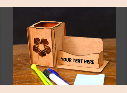Wooden pen holder with business card stand on a wooden surface with stationery items.