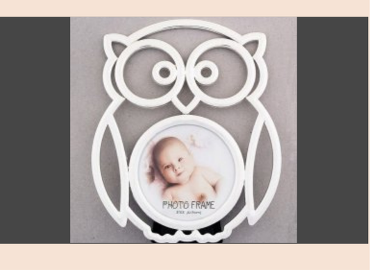 White owl-shaped photo frame with a baby photo inside on a gray background