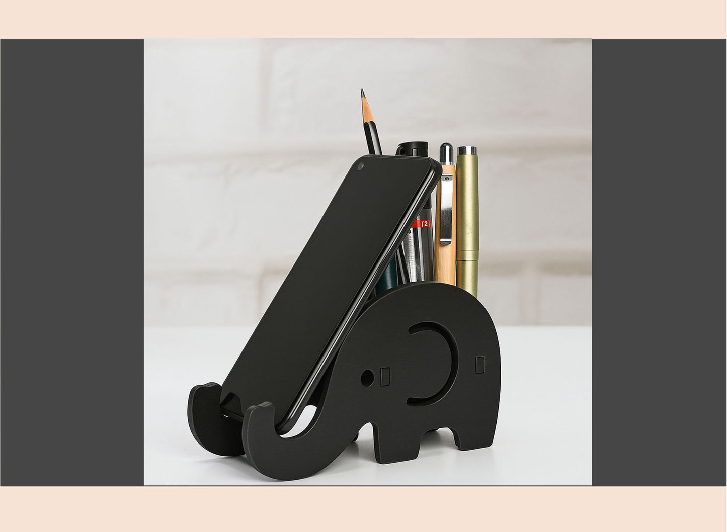 Black elephant-shaped desk organizer with stationery items on a light surface.