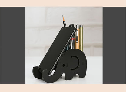 Black elephant-shaped desk organizer with stationery items on a light surface.