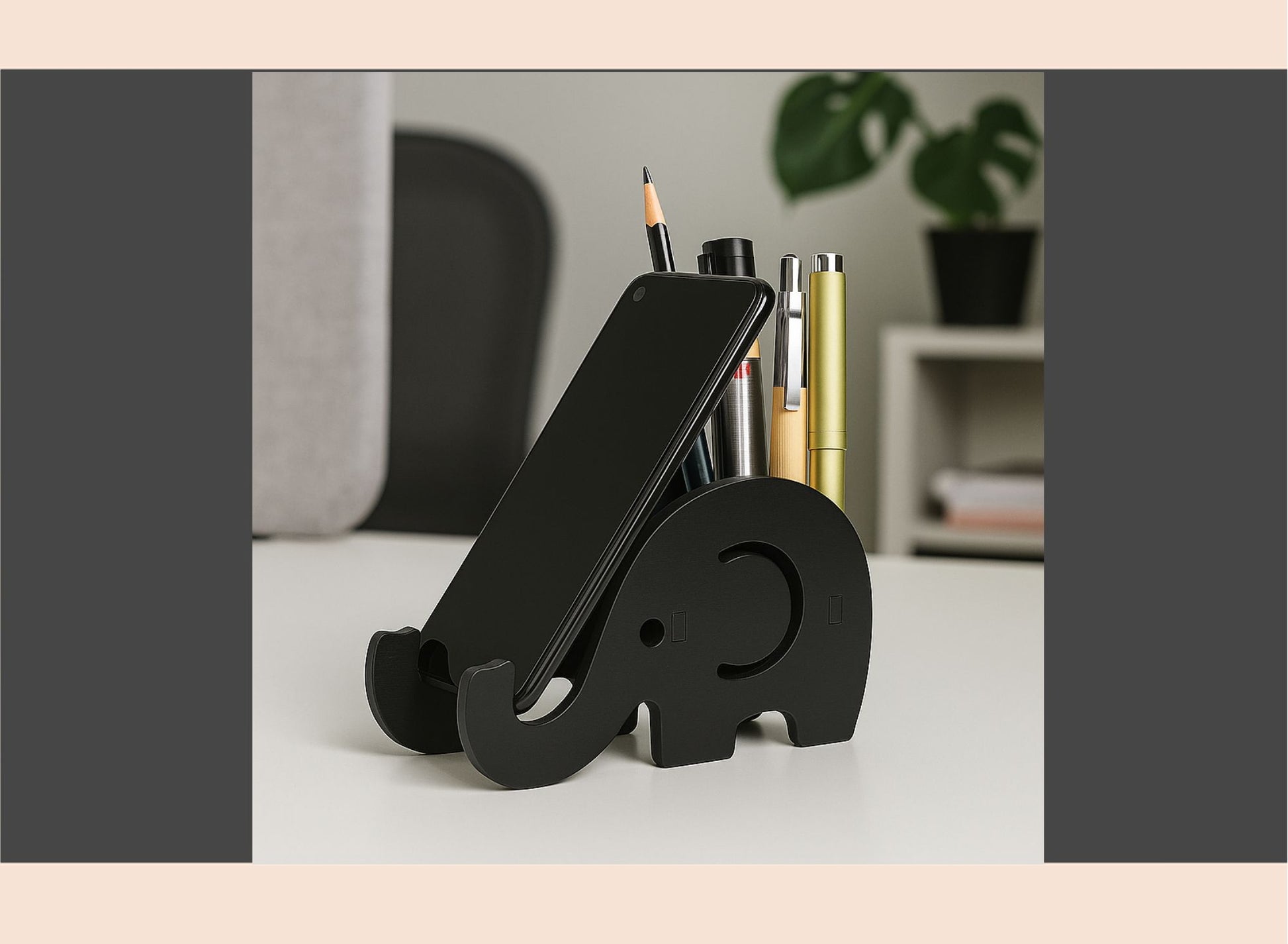 Black elephant-shaped phone stand on a desk with office supplies.