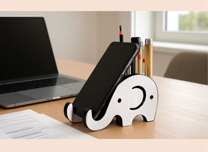 Phone stand shaped like an elephant on a desk with a laptop and stationery items.