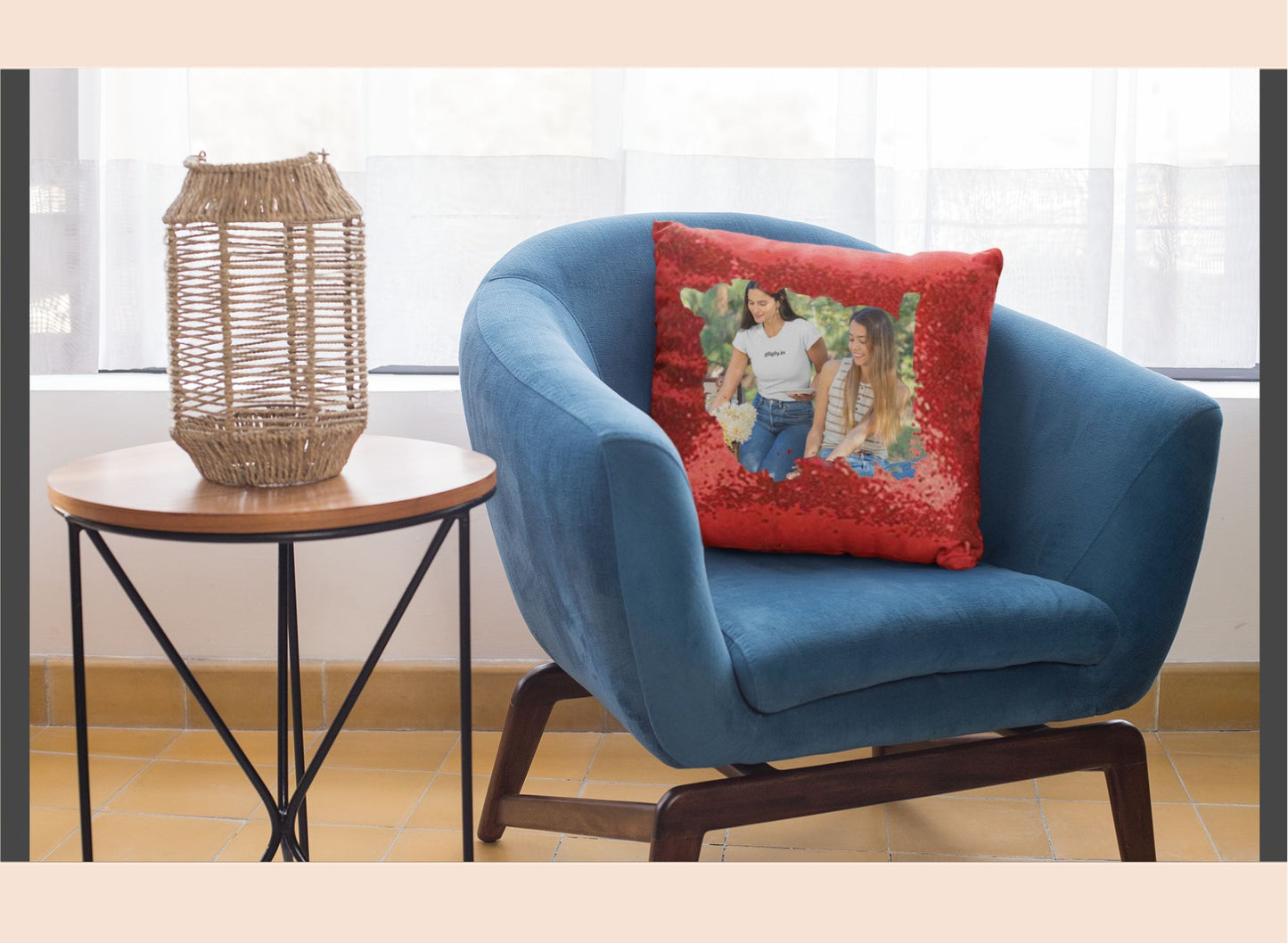 Blue armchair with a red pillow featuring a woman and child, next to a small round table with a woven basket.
