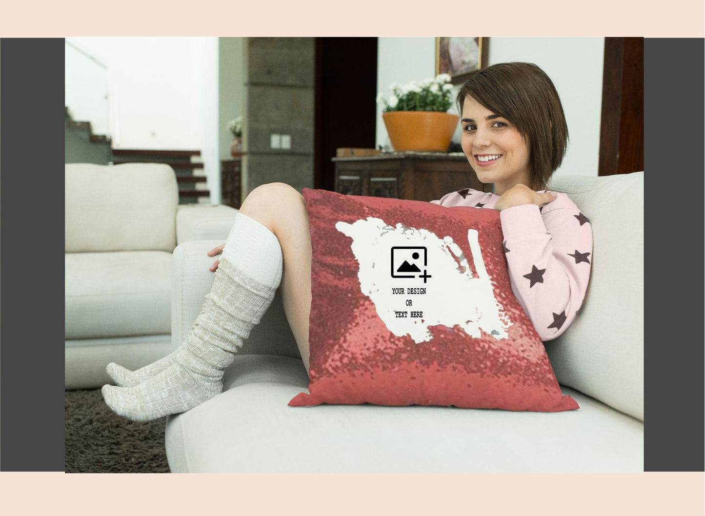 Woman sitting on a couch with a red pillow featuring a white design.