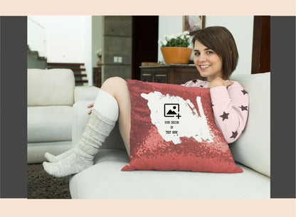 Woman sitting on a couch with a red pillow featuring a white design.